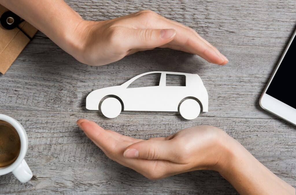To hender rundt hvit bil som illustrerer bilforsikring og forsikring av bil