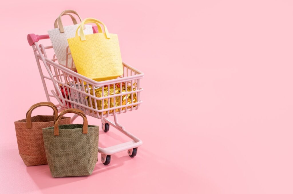 Handlevogn på rosa bakgrunn som illustrerer kjøp finansiert av forbrukslån